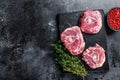 Raw lamb neck meat on a marble board..Black background. Top view. Copy space