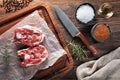 Raw lamb neck meat on white cooking paper and wooden cutting table