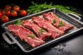 raw lamb rack on steel tray with scattered herbs Royalty Free Stock Photo