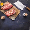 Raw lamb ribs on a cutting board with salt and pepper and vintage cleaver, border, place for text on wooden rustic background top Royalty Free Stock Photo