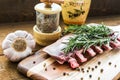 Raw lamb ribs with rosemary, pepper, garlic and oil on wooden board Royalty Free Stock Photo