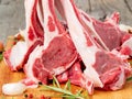 Raw lamb ribs on wooden chopping Board on old rustic wooden back Royalty Free Stock Photo
