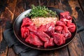 Raw lean diced casserole beef meat for cooking Goulash. Wooden background. Top view