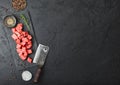 Raw lean diced casserole beef pork steak on chopping board with vintage meat hatchet on stone background. Salt and pepper with