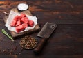 Raw lean diced casserole beef pork steak on chopping board with vintage meat hatchet on wooden background. Salt and pepper with