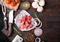 Raw lean diced casserole beef pork steak with vintage meat hatchet and knife and fork on wooden background. Salt and pepper with