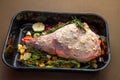 Raw Leg of lamb in roasting tray dressed with vegetables Royalty Free Stock Photo