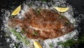 Raw lemon sole fish on ice with herbs and lemon wedges Royalty Free Stock Photo