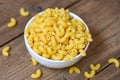 Raw macaroni uncooked delicious pasta or penne noodles - macaroni on bowl and wooden background , top view Royalty Free Stock Photo