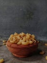 Raw macaroni with wooden bowl on table