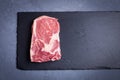 Raw marble, fresh piece of meat, black Angus ribeye steak on a dark stone background. Royalty Free Stock Photo