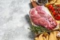 Raw marble pork steak on a wooden chopping Board. Organic meat. Gray background. Top view. Copy space Royalty Free Stock Photo