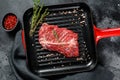 Raw marbled beef steak on a grill pan. Black background. Top view Royalty Free Stock Photo