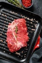 Raw marbled beef steak on a grill pan. Black background. Top view Royalty Free Stock Photo