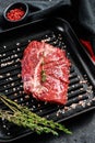 Raw marbled beef steak on a grill pan. Black background. Top view Royalty Free Stock Photo