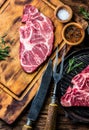 Raw marbled beef steaks on wooden cutting board