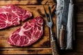 Raw marbled beef steaks on wooden cutting board