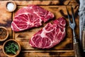 Raw marbled beef steaks on wooden cutting board