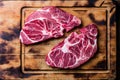 Raw marbled beef steaks on wooden cutting board