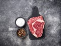 Raw marbled ribeye steak and spices