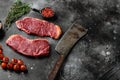 Raw Marbled sirloin Beef Steaks, on black dark stone table background, with copy space for text