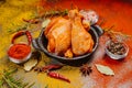 Raw marinated chicken drumsticks sprinkled with spice, chili pepper pieces, bay leaves prepared to cook in a dish, view from above Royalty Free Stock Photo