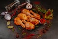 Raw marinated chicken drumsticks sprinkled with spice, chili pepper pieces, bay leaves prepared to cook in a dish, view from above Royalty Free Stock Photo