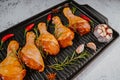 Raw marinated chicken drumsticks sprinkled with spice, chili pepper pieces, bay leaves prepared to cook in a dish, view from above Royalty Free Stock Photo