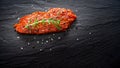 Raw marinated meat, beef steak on black slate background, top view
