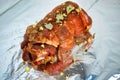 Raw marinated pork roll sprinkled with spices and tied with string. Lying on foil. Royalty Free Stock Photo