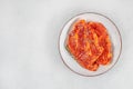Raw marinated pork steaks with spices and herbs on white plate. top view. copy space Royalty Free Stock Photo