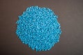 Raw material plastic granules light blue cyan, close-up raw material brown background!