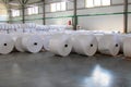 Raw materials warehouse. Many large coils of finished propylene hose made of woven thread for making industrial bags
