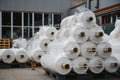 Raw materials warehouse. Many large coils of finished propylene hose made of woven thread for making industrial bags.