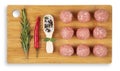 Raw meat balls on a chopping board. Rosemary, chili pepper, spices. White background. Top view Royalty Free Stock Photo