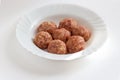 Raw meat balls with rice, spices, sauce, finely chopped cabbage are ready for cooking. A few raw noisettes lie on a white plate