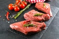 Raw meat. Raw beef steak on a black board with herbs and spices. Close-up Royalty Free Stock Photo