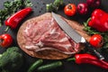 Raw meat, beef steak on cutting board with knife on black background with ingredients for cooking. Royalty Free Stock Photo