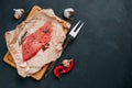 Raw meat, beef steak with grill fork, herbs and spices, flat lay Royalty Free Stock Photo