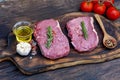 Raw meat beef steak organic fresh ingredient on wooden board table background in kitchen with rosemary, salt, garlic, tomato, Royalty Free Stock Photo
