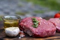 Raw meat beef steak organic fresh ingredient on wooden board table background in kitchen with rosemary, salt, garlic, tomato, Royalty Free Stock Photo