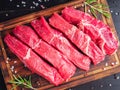 Raw meat, beef steak with seasoning on chopping board on dark ba Royalty Free Stock Photo