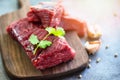 Raw meat beef steak with spices garlic on wooden cutting board and black background, top view - Fresh beef piece for steak or Royalty Free Stock Photo