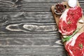 Raw meat, beef steak with spices and rosemary on wooden cutting board Royalty Free Stock Photo