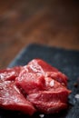 Raw meat beef steaks on black slate board with spices and rosemary over wooden background, copy space Royalty Free Stock Photo