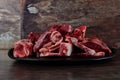 Raw meat with bone on clay plate and brown stone background.Raw meat with beef bone