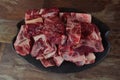 Raw meat with bone on clay plate and brown stone background.Raw meat with beef bone