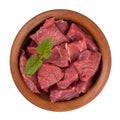 Raw meat is cut into pieces in a brown plate.