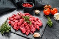 Raw meat cut into thin strips for beef Stroganoff. Black background. Top view Royalty Free Stock Photo