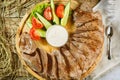 Raw meat with herbs, seasonings, tomato cherry, cucumbers and white souce cream on wooden round table. Row beef steak grill pan s Royalty Free Stock Photo